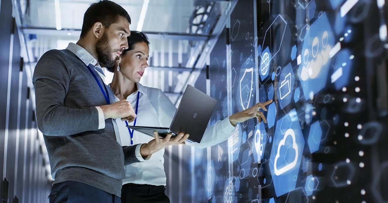 Man and woman working in server room on computers